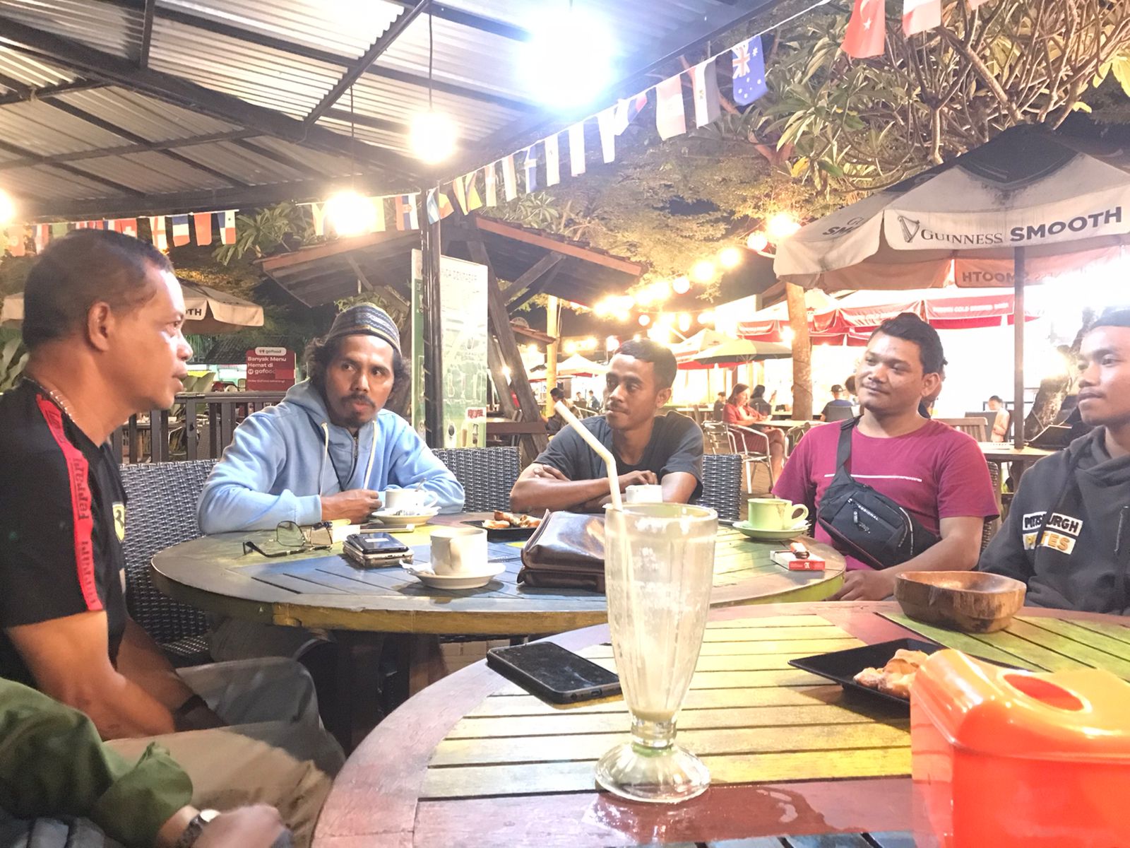 Emanuel Dewata Oja (paling kiri) dan Kepala Desa Gara Kecamatan Satar Mese Tengah, Yohanes Mario Nombo (dua dari kiri) serta beberapa mahasiswa Manggarai saat diskusi santai di Warung Pica, Kompleks Kuliner Pojok Sudirman Denpasar, Kamis 8 Juni 2023.